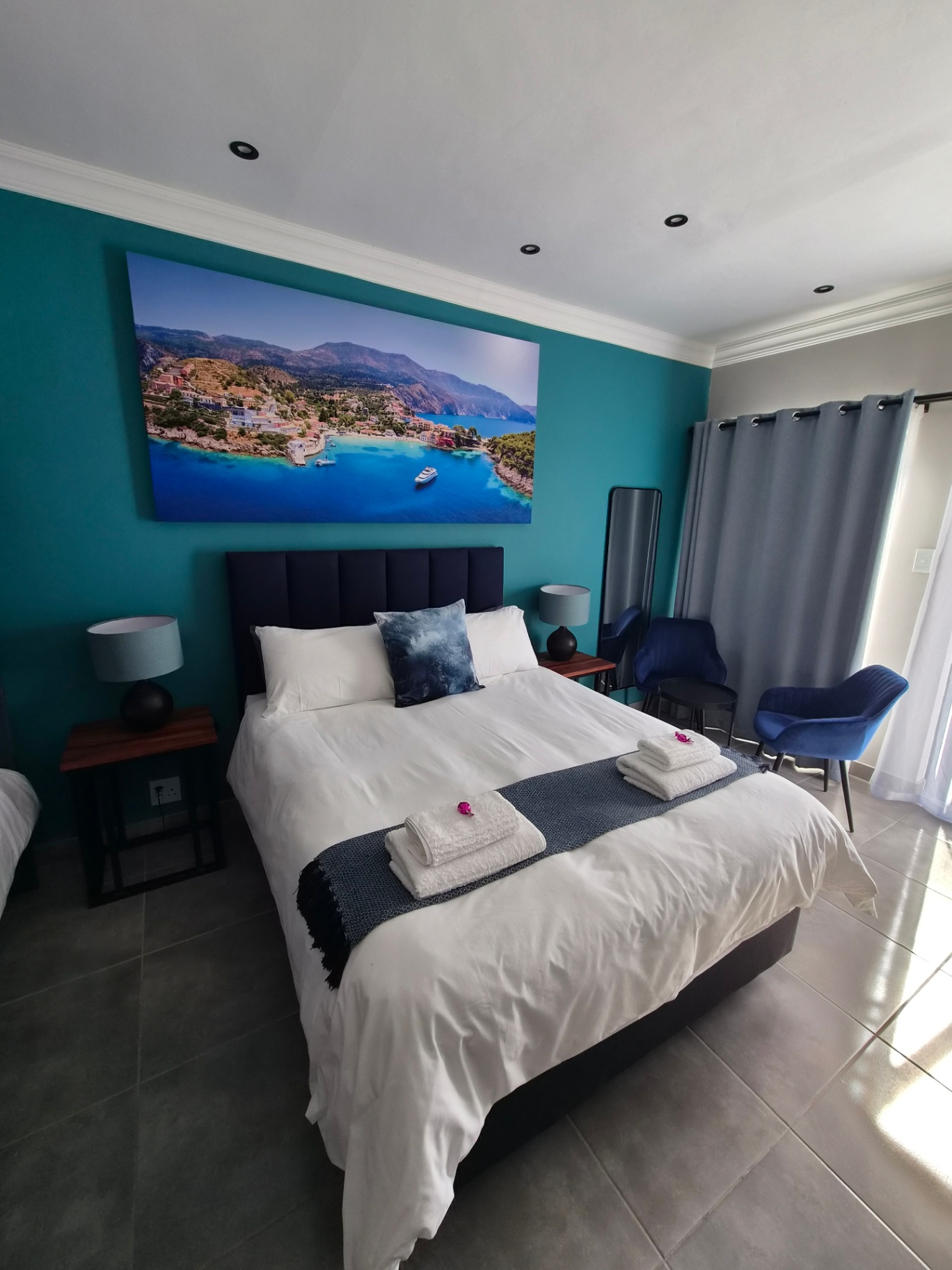 Room Frantoio with queen bed and Mediterranean artwork