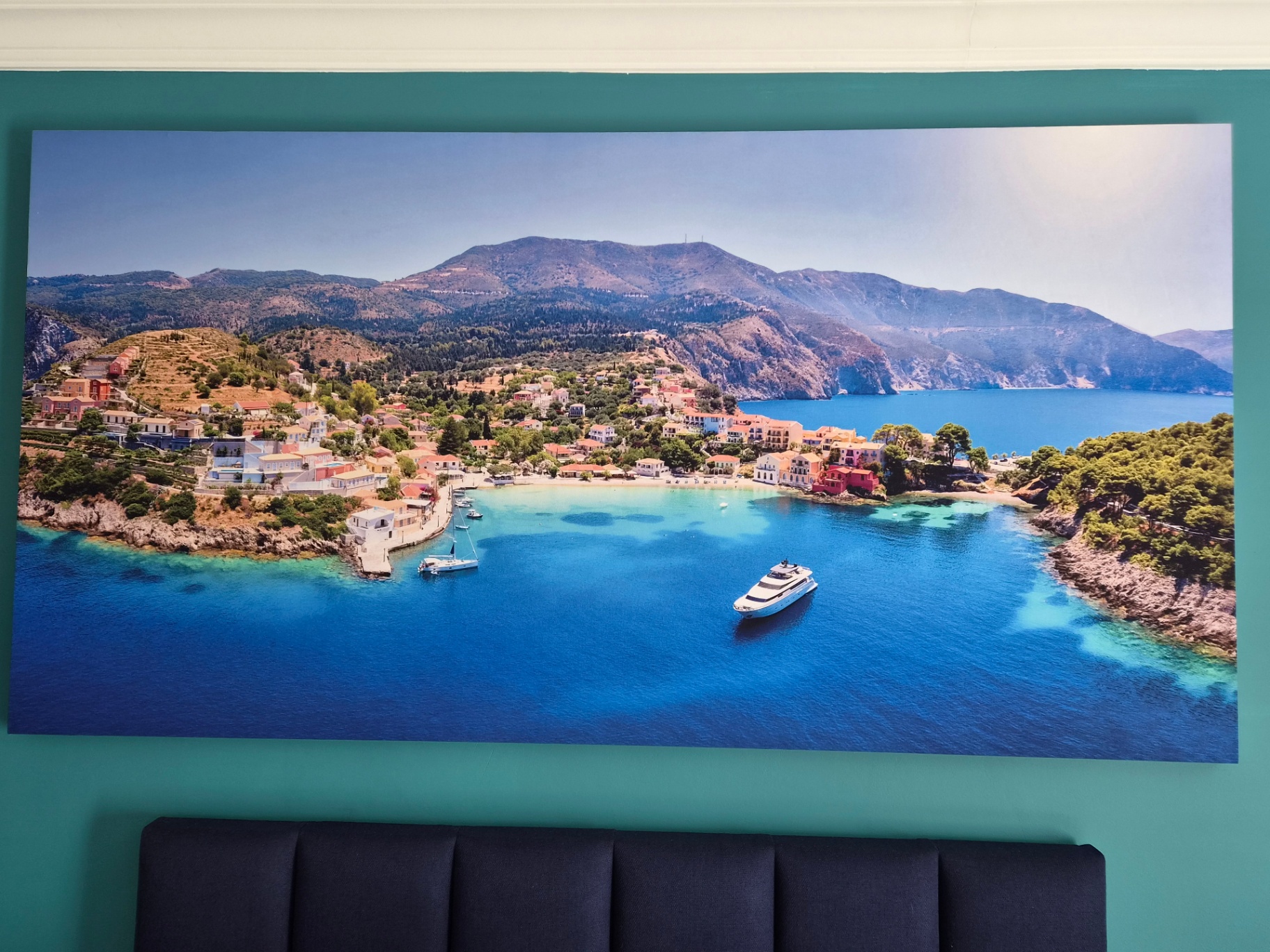 Assos coastal artwork above the bed in Room Frantoio