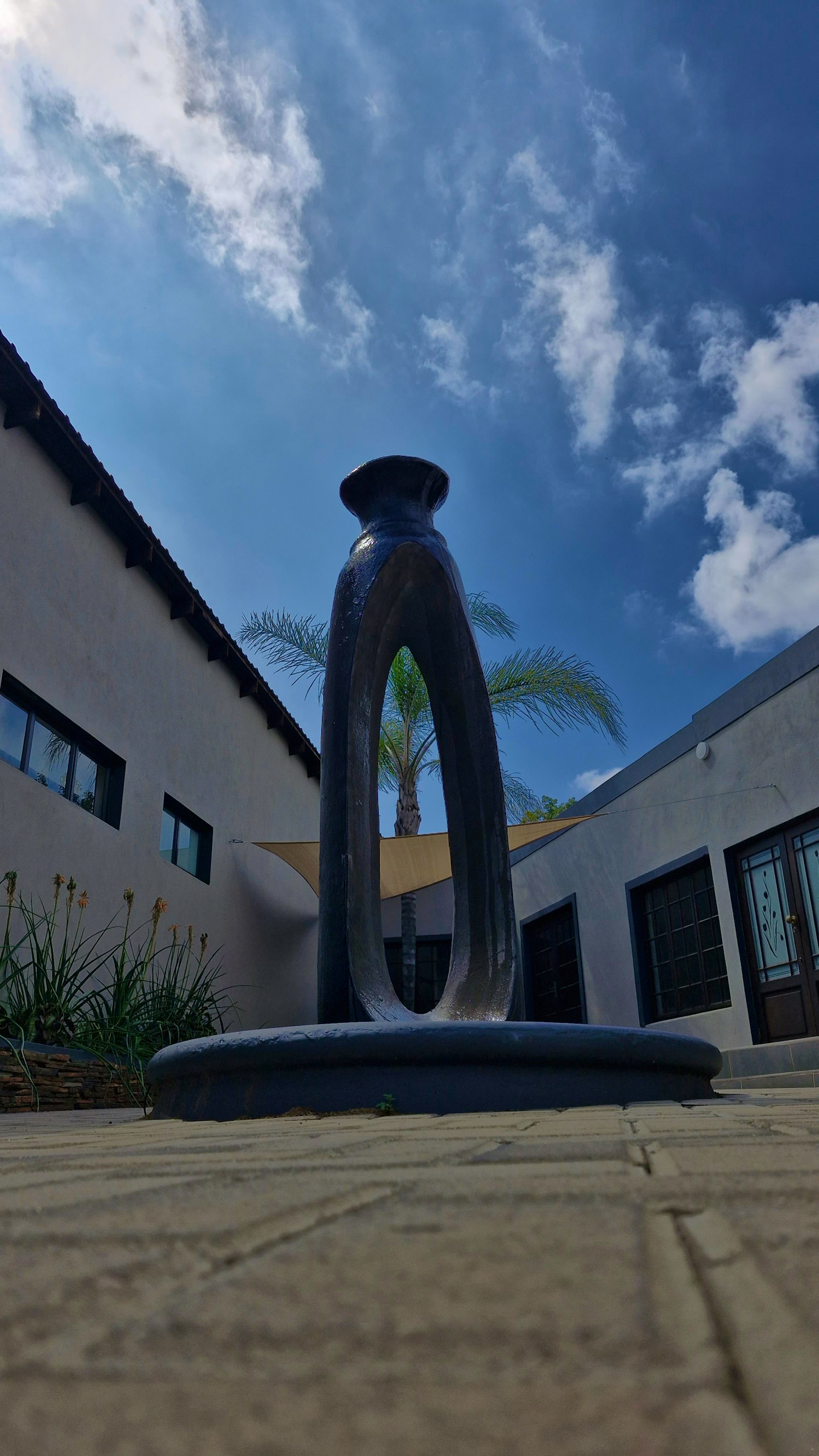 The olive-press sculpture against the sky